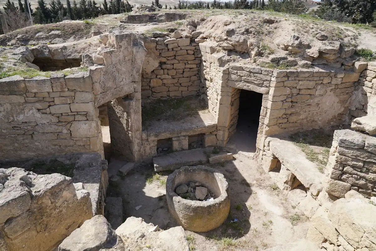 Fondazioni in pietra e strutture antiche durante uno scavo archeologico