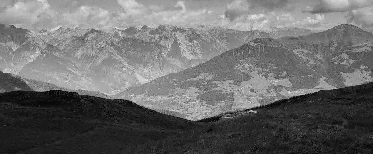 Paesaggio montuoso isolato che rappresenta le regioni geograficamente separate dove fiorisce la diversità linguistica.
