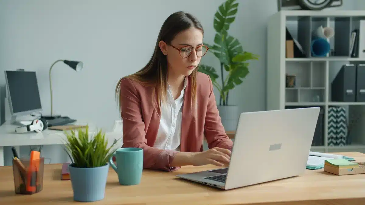 Persona che esamina documenti e dati di automazione alla scrivania con schermo di computer