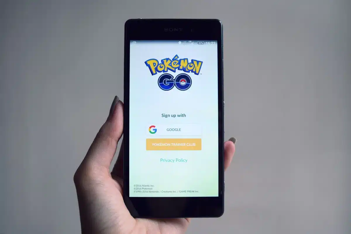 Persone che giocano all'aperto con realtà aumentata su smartphone, esplorando uno spazio pubblico.