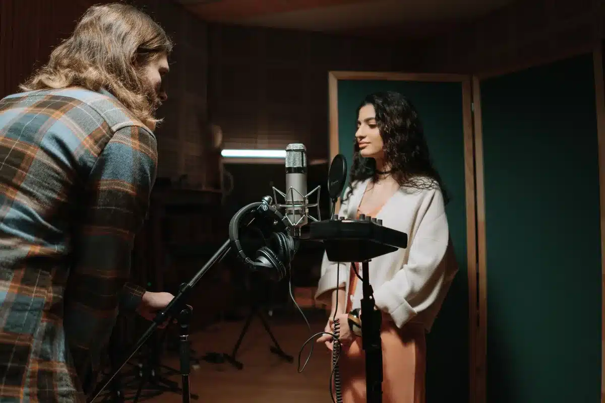 Studio di produzione musicale con interfaccia digitale e tracce multilingue su schermo