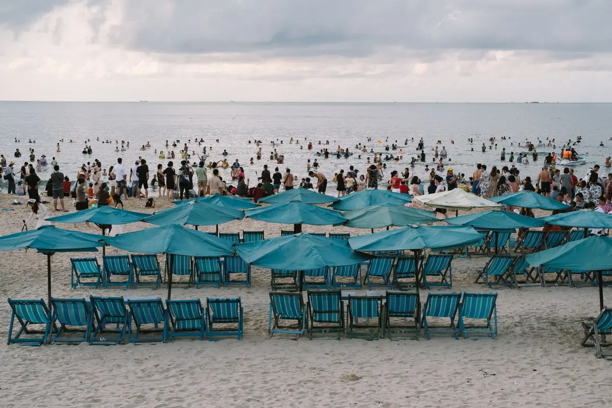 Spiaggia affollata d'estate con strutture turistiche e bagnanti durante la stagione alta