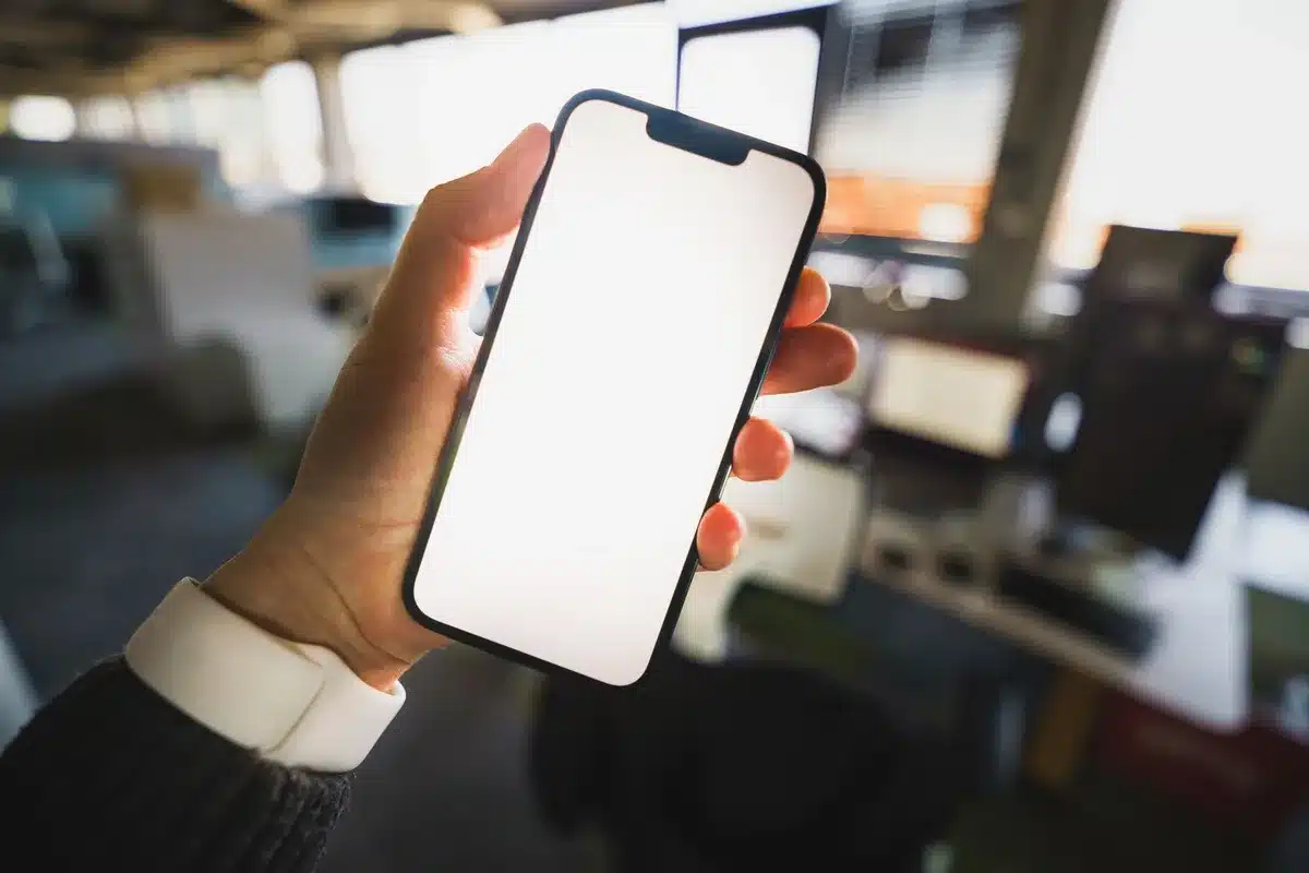 Mano che tiene uno smartphone con notifica di chiamata in arrivo su schermo scuro