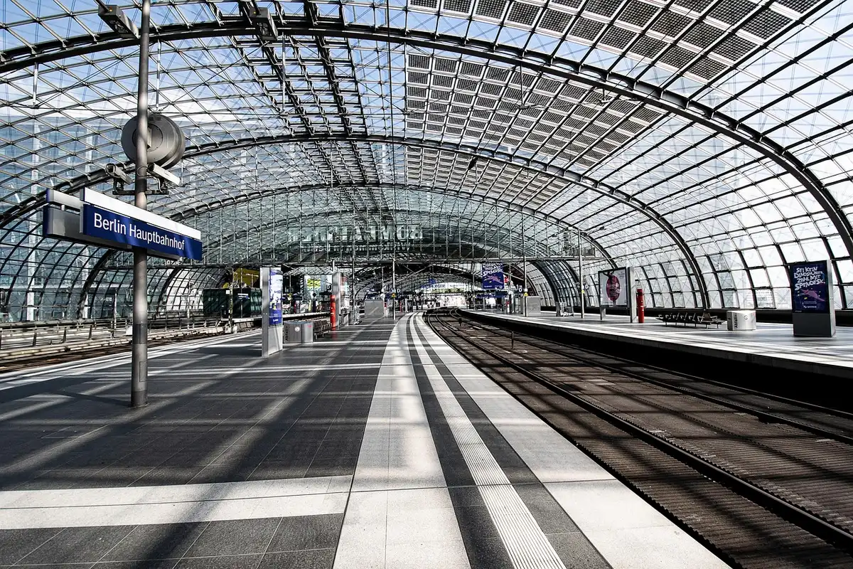 Banchina espositiva con tecnici anonimi e pannelli informativi su progetti ferroviari
