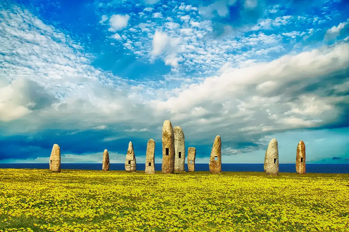 Mani anonime con piccole punte di pietra triangolari distese su un panno, sfondo montano sfocato