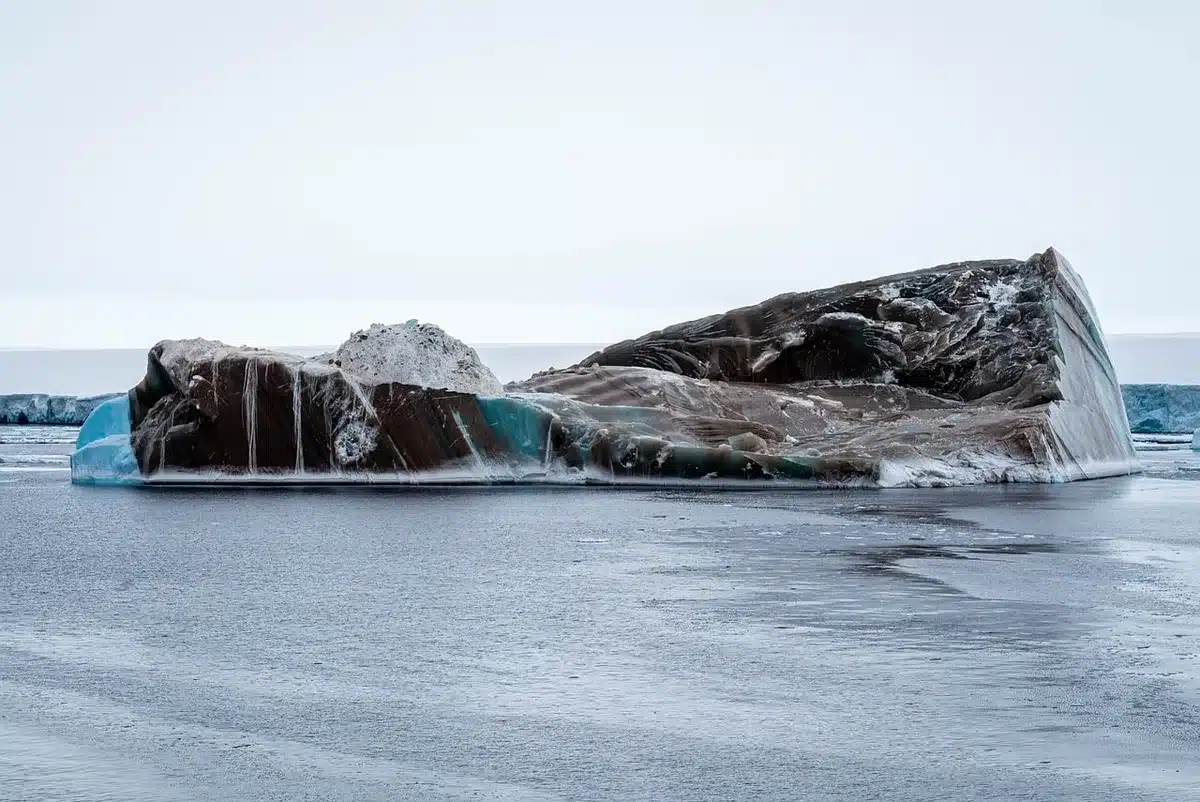 Tende anonime e pezzi di slitta su una spiaggia artica innevata, cielo grigio