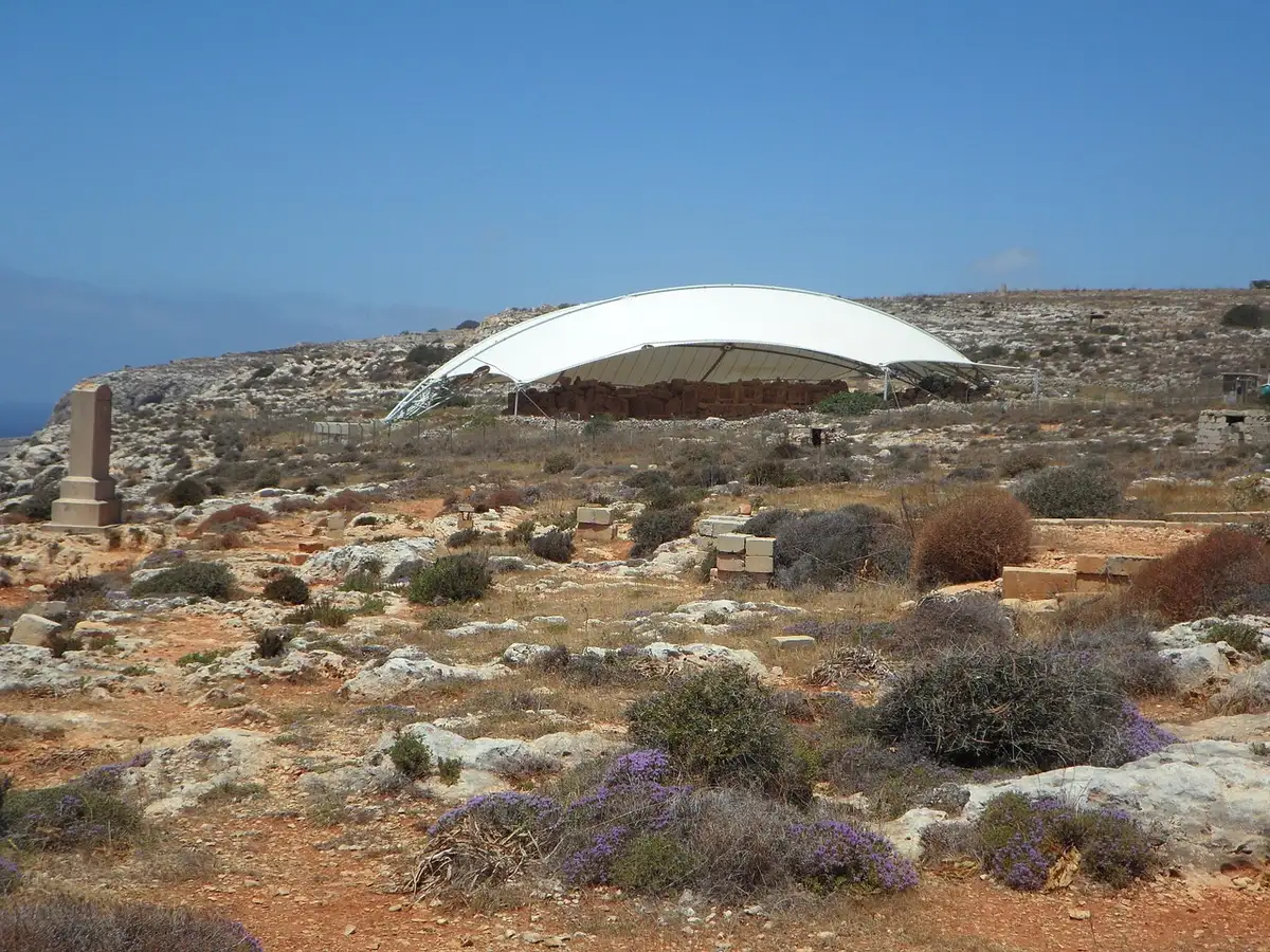 Scavo archeologico in una grotta con strati sedimentari del Paleolitico