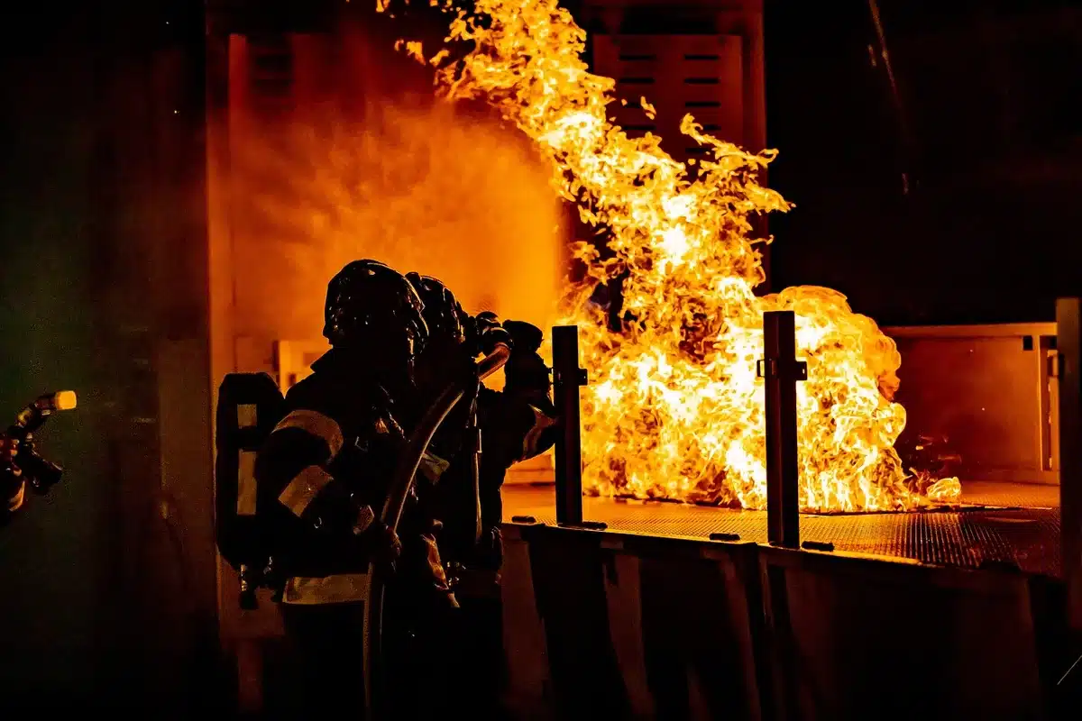Vigile del fuoco in azione tra fiamme e calore intenso durante intervento di emergenza