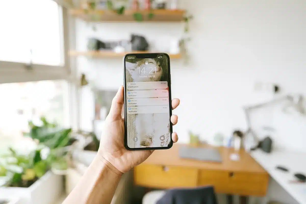Schermo di smartphone con notifiche e mano che scrolla, simbolo di gratificazione immediata