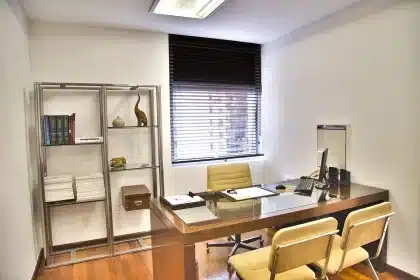 Fascicoli medici e occhiali su un tavolo in una sala d'attesa clinica