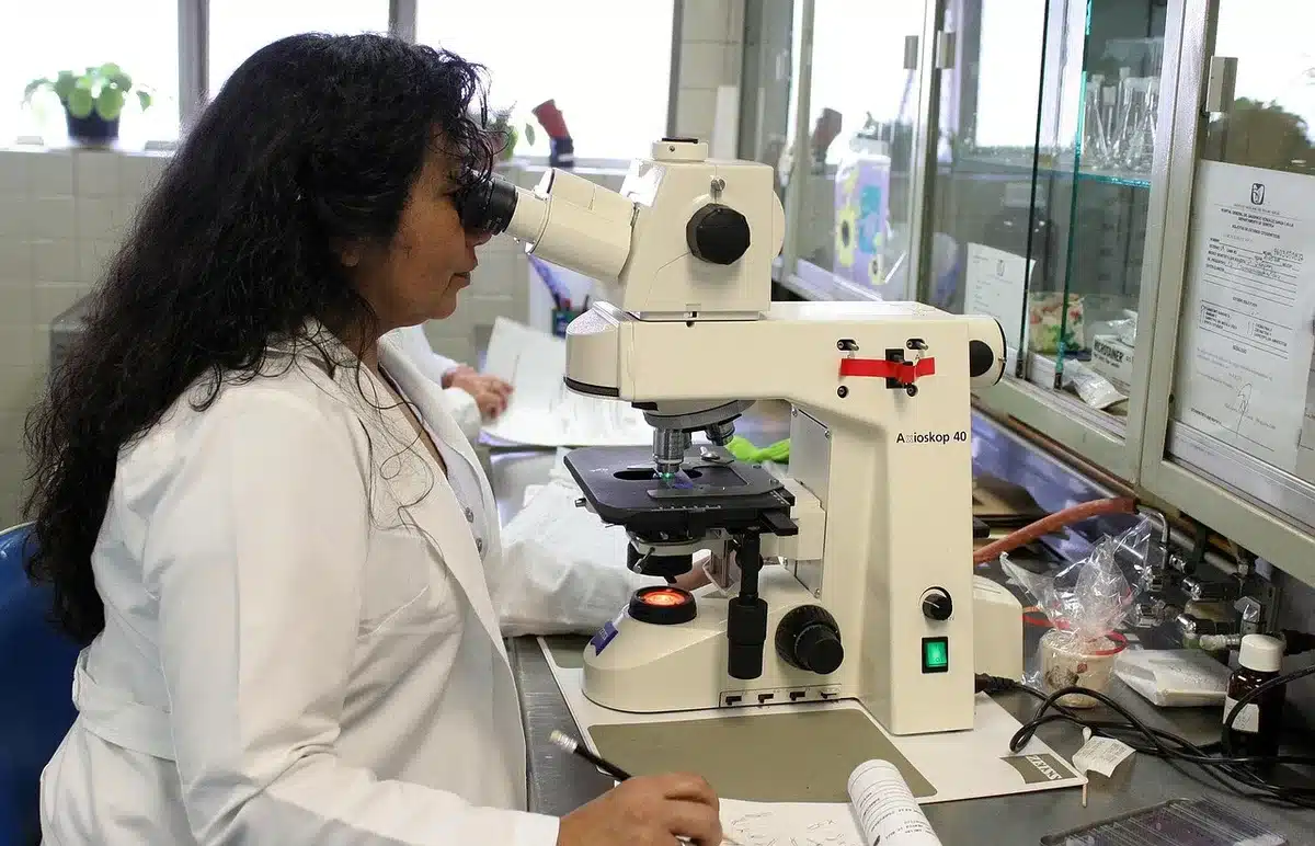 Ricercatore che consulta appunti su trial clinico in laboratorio