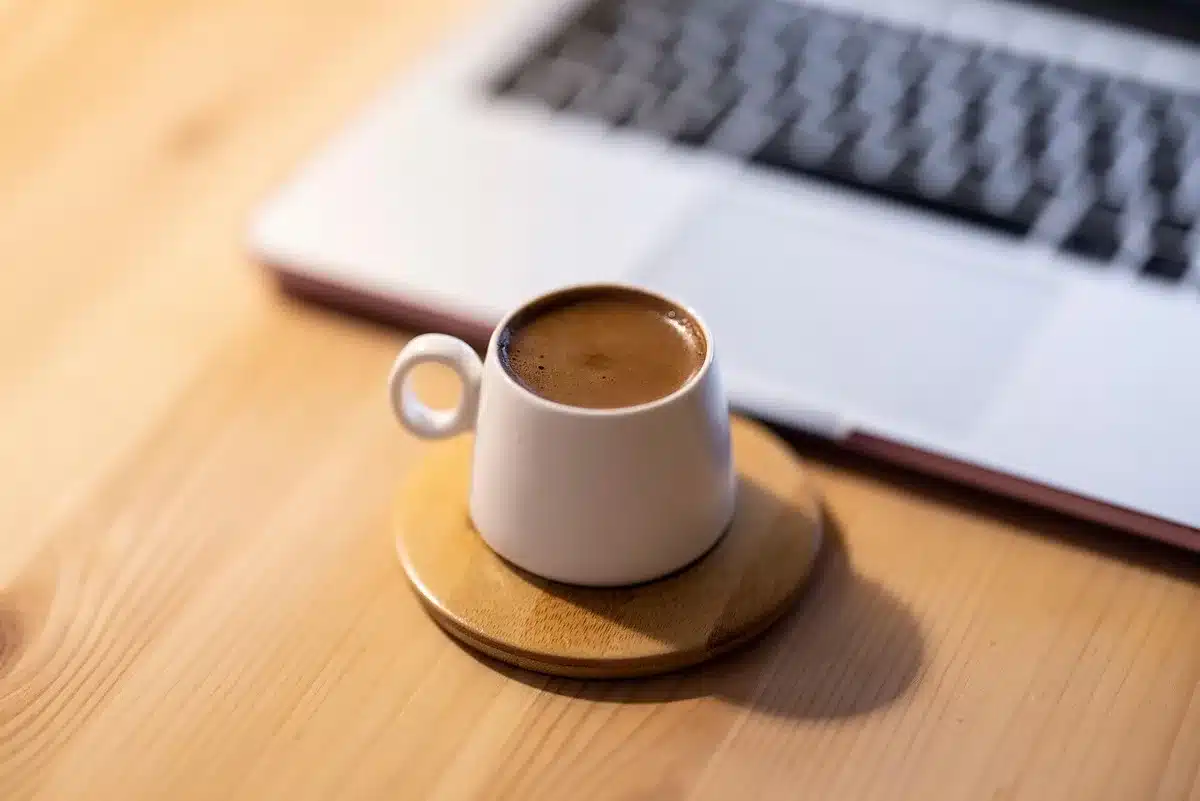 Schermo di laptop che mostra promozioni di viaggio, vicino a una tazza di caffè