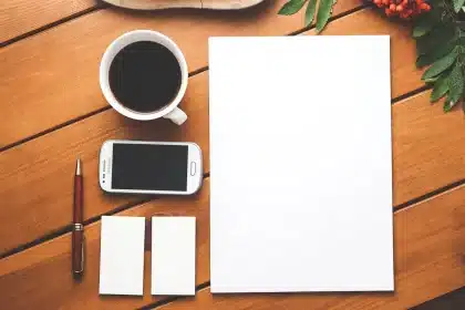 Mani anonime che tengono smartphone e carta contactless su un tavolo