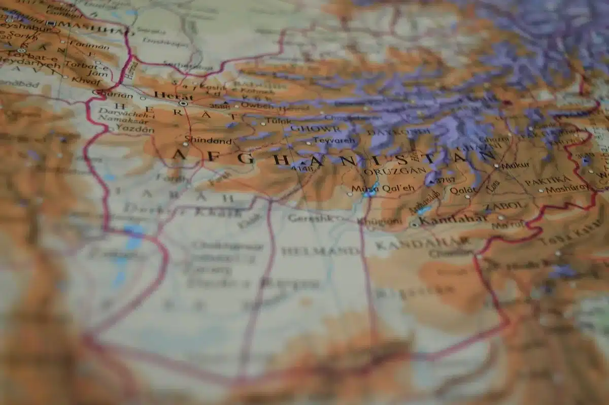 Mani anonime e monete antiche sparse su un tavolo con una mappa e un calibro