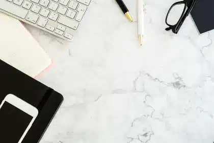 Redazione anonima con smartphone e appunti su un tavolo, scena mobile-first